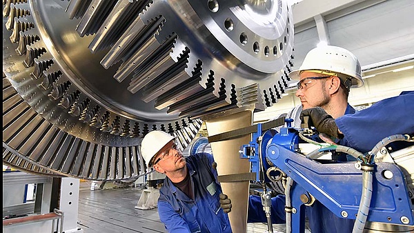 Zwei Mechaniker montieren Maschinenteile in einer Werkstatt
