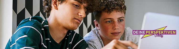Zwei Jugendliche schauen auf einen Laptop