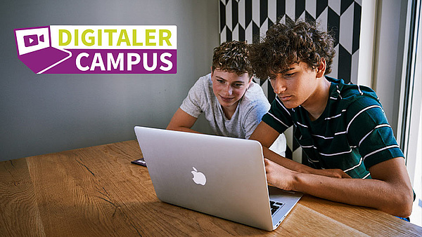 Zwei Jugendliche vor einem Laptop, die sich den Digtalen Campus der Ausbildungsoffensive Bayern ansehen