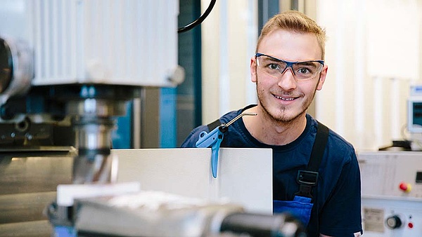 Ein auszubildender Mechaniker sitzt in der Werkstatt