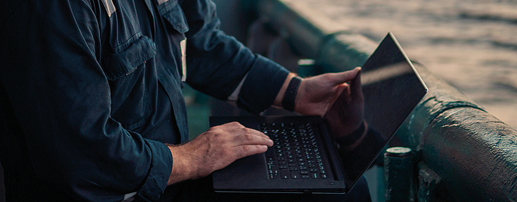 Mann mit Laptop bei der Arbeit im Bereich Meerestechnik