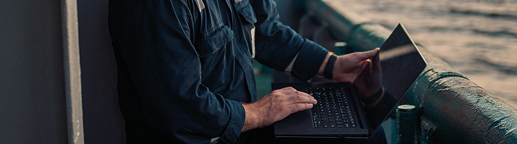 Mann mit Laptop bei der Arbeit im Bereich Meerestechnik