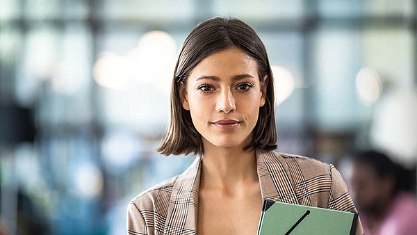 Eine Kauffrau für Büromanagement steht in ihrem Büro