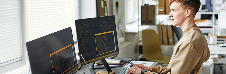 Ein Man macht Datenanalyse am Computer.