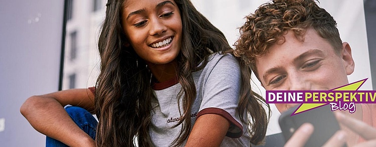 Zwei Jugendliche schauen auf ein Handy