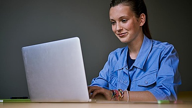 Jugendliches Mädchen verfasst ihre Bewerbung am Laptop.