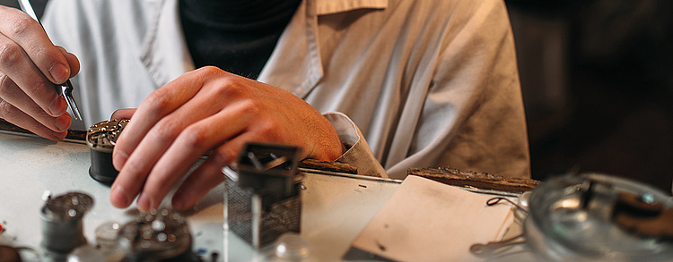 Zwei Hände bei der Arbeit in der Feinmechanik