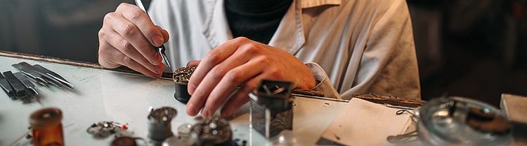 Zwei Hände bei der Arbeit in der Feinmechanik