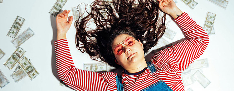 Junge Frau mit Laptop schaut nachdenklich