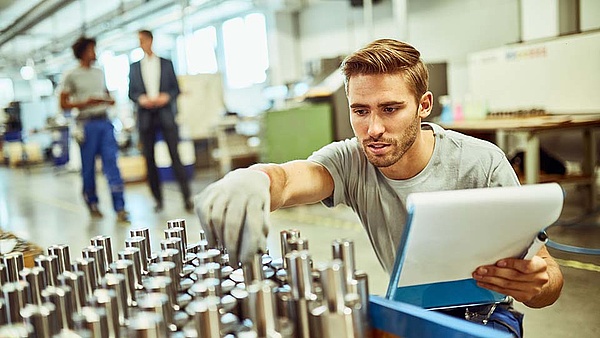 Ein Mechaniker kontrolliert fertiggestellte Werkstücke aus der Produktion